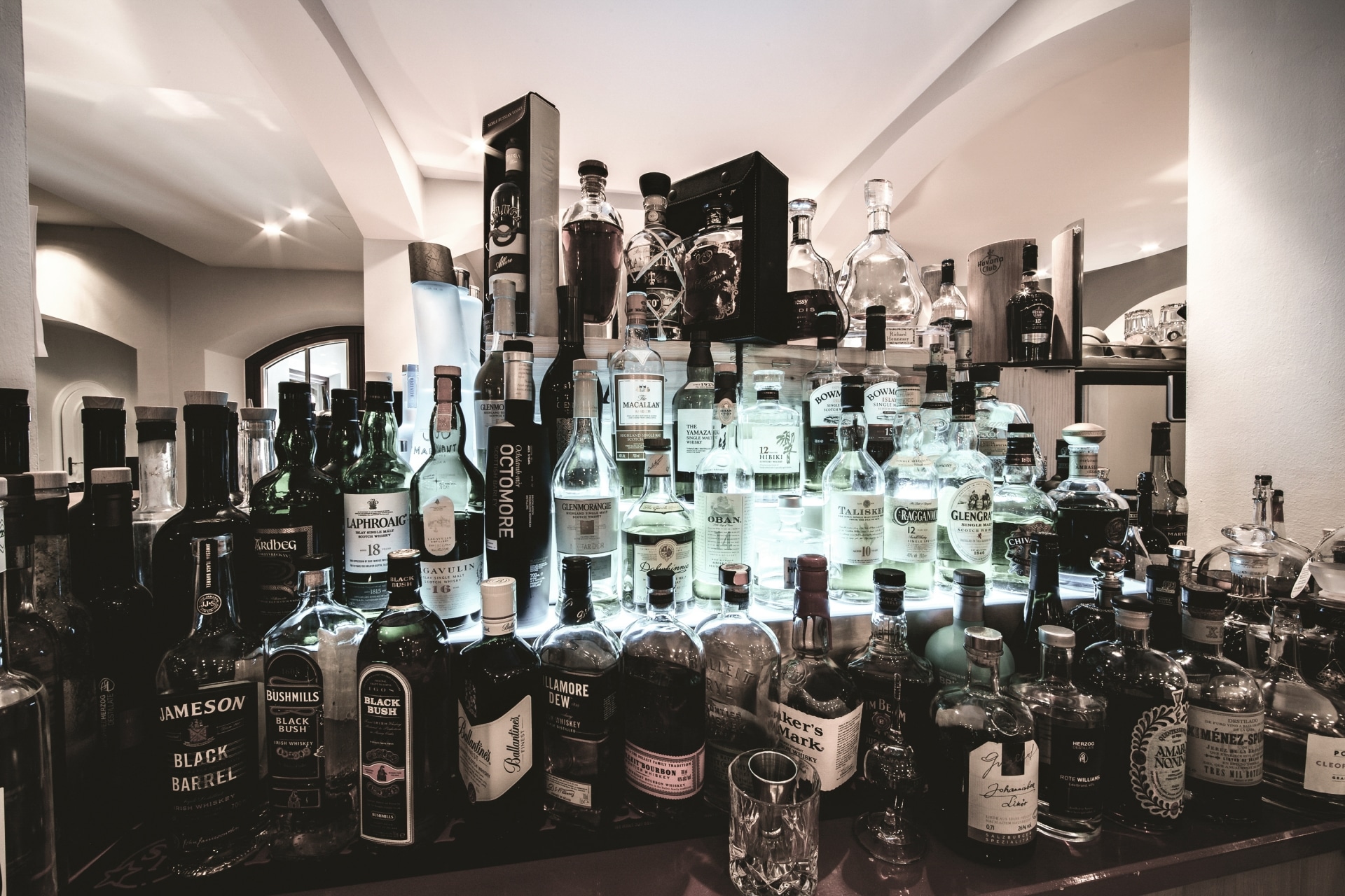 An assortment of spirits and liquor bottles on a bar shelf, showcasing a variety of brands and types of alcohol.